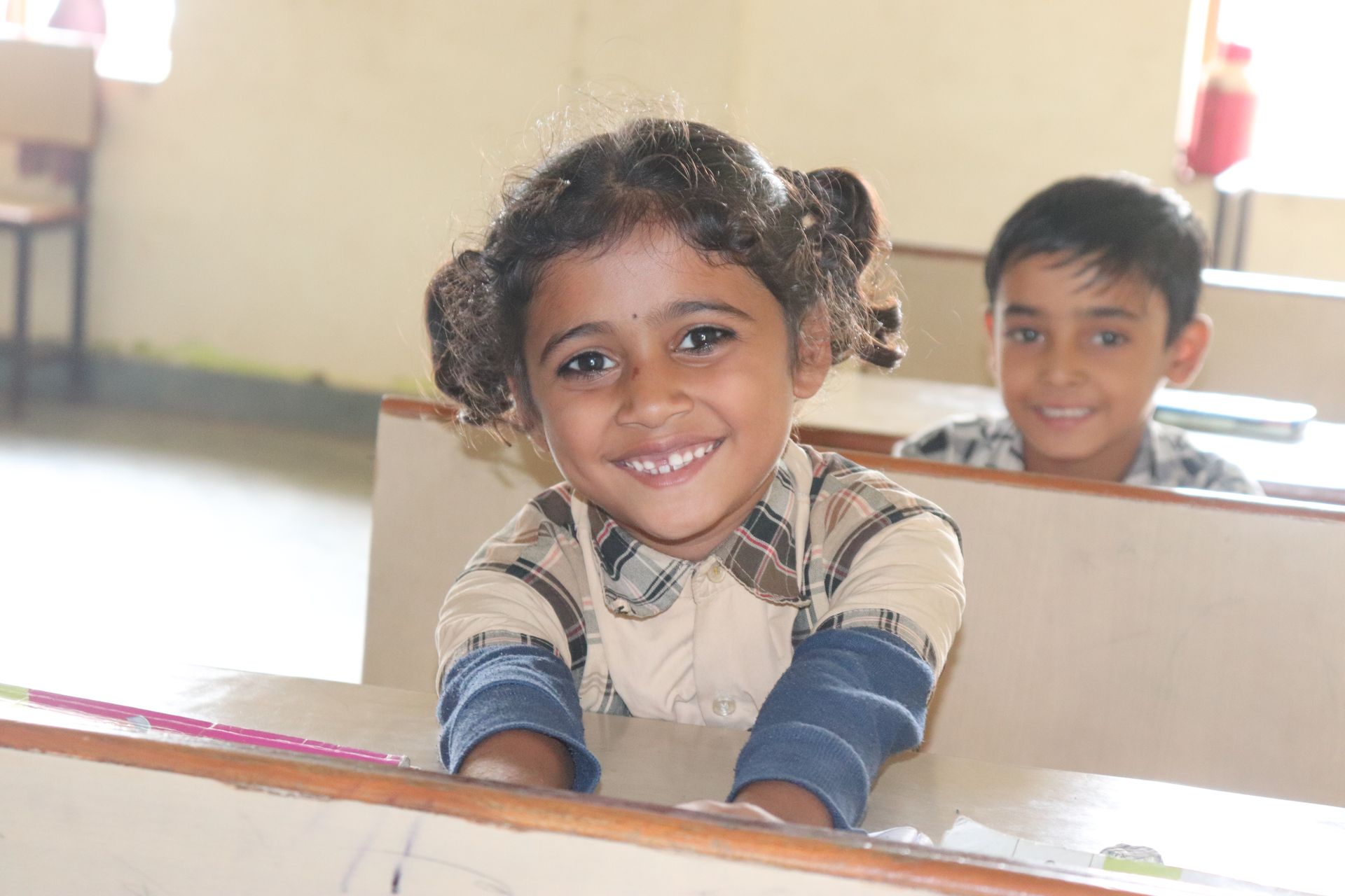 A young student smiling at her desk